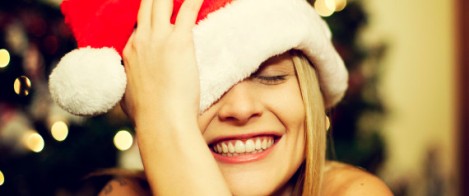 Single vrouw die zich amuseert met een kerstmuts op haar hoofd